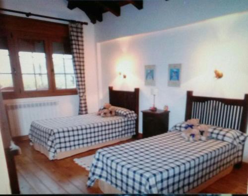 a bedroom with two beds with teddy bears on them at El Collado in El Rasillo