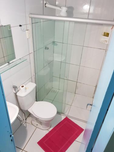 a bathroom with a toilet and a glass shower at Hotel Pousada Maravista in Natal