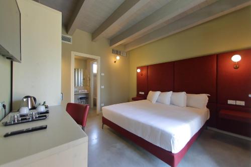 a bedroom with a large white bed and a desk at La Boheme Chambres in Lazise