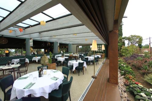 a restaurant with white tables and chairs and tablesearcher at La Boheme Chambres in Lazise