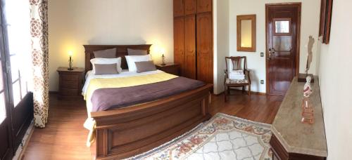 a bedroom with a large bed with a wooden headboard at Apartamentos na Casa São Bernardo in Alcobaça