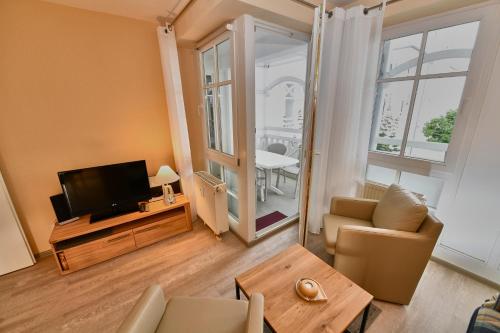 ein Wohnzimmer mit Fernseher, Couch und Tisch in der Unterkunft Seepark Sellin - Apt. 404 in Ostseebad Sellin