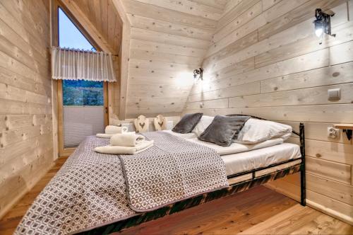 ein Schlafzimmer mit einem Bett in einer Holzhütte in der Unterkunft Domki U Jadzi in Zakopane