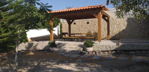 a wooden bench sitting under a wooden pergola at FIND Your Space Casa no Campo - Paderne - Albufeira - Piscina Privada - Aquecida a pedido in Paderne