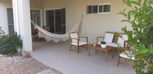 a porch with chairs and a hammock on a house at FIND Your Space Casa no Campo - Paderne - Albufeira - Piscina Privada - Aquecida a pedido in Paderne
