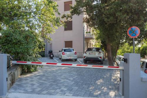 two cars parked in a parking lot next to a building at Five Elements Luxury Rooms in Split