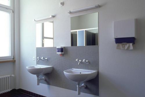 a bathroom with two sinks and a mirror at Zurich Youth Hostel in Zurich
