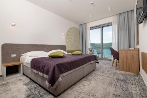 a bedroom with a large bed and a large window at Hotel Nova in Neum