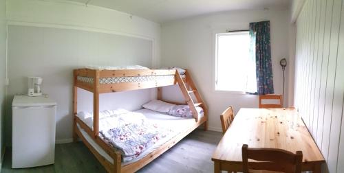 1 dormitorio con 2 literas y mesa en Romsdalseggen Camping en Isfjorden