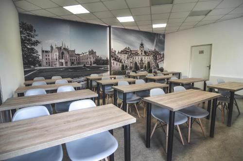 a classroom with tables and chairs and a painting on the wall at Penzion Pod Radnicí in Hustopeče