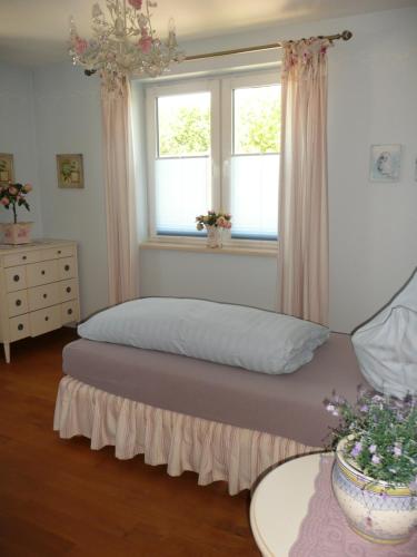 ein Schlafzimmer mit einem Bett und zwei Fenstern in der Unterkunft Gästehaus Grothe in Zinnowitz