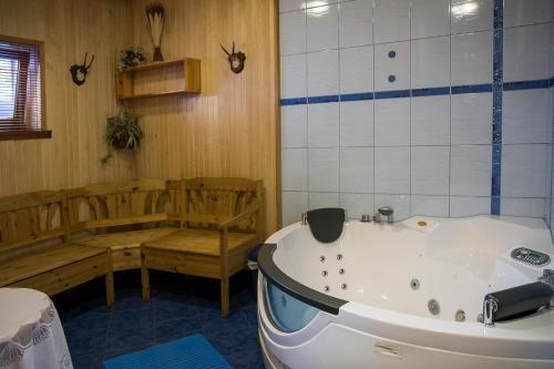 ein Bad mit einer Badewanne und einer Bank in einem Zimmer in der Unterkunft Veski Guesthouse in Antsla