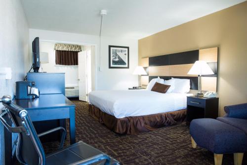 a hotel room with a bed and a chair at Eastern Inn in Bourne