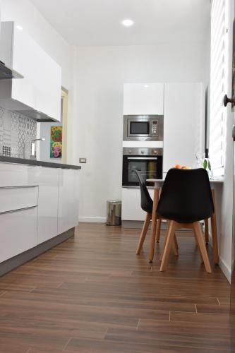 a kitchen with white cabinets and a table and chairs at b&b Donna Raffaela in Crotone