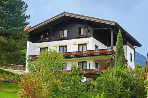 a black and white house with flowers on the windows at Pension Seirer in Sankt Radegund bei Graz