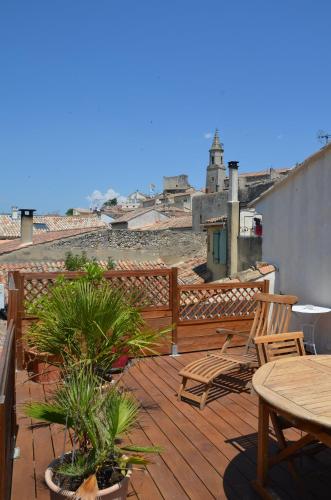 a patio with a table and chairs on a deck at Gite DURANCE in Mallemort