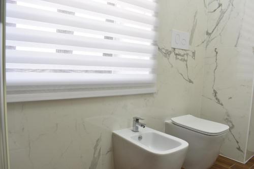a bathroom with a white toilet and a window at b&b Donna Raffaela in Crotone
