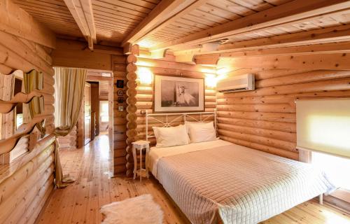 a bedroom with a bed in a log cabin at Lakkia - Wooden Residence in Lakkiá