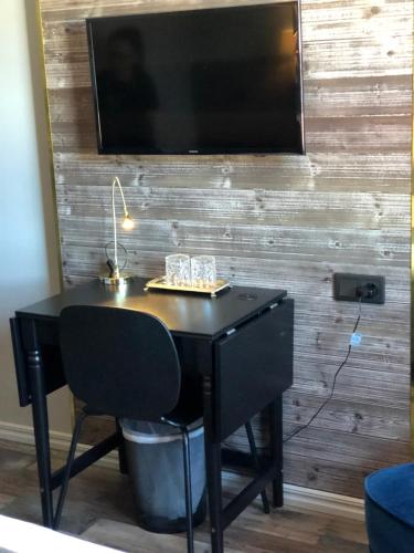 a black desk with a television on a wall at Hotell Älvdalen in Älvdalen