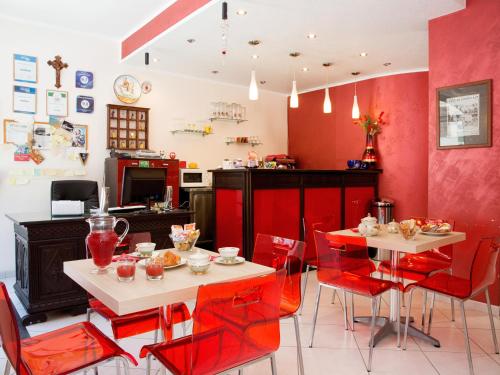 a dining room with red walls and red chairs at Sosta dei Garibaldini in Campofelice di Roccella