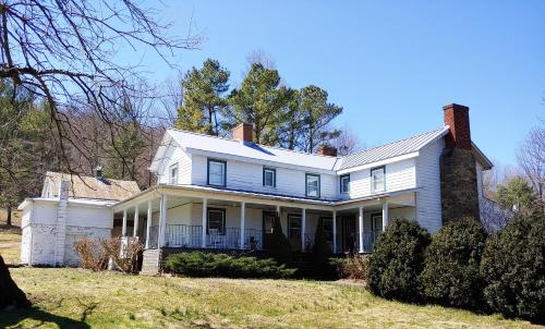 a white house with a chimney on top of it at Graves Mountain Farm & Lodges in Syria