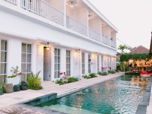 a swimming pool in the courtyard of a building at Hikari Guesthouse in Seminyak
