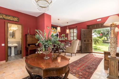 a living room with red walls and a table with flowers on it at Alquería Calatrava B&B in Burriana