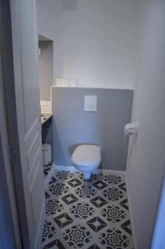 a bathroom with a toilet and a black and white tile floor at Gite DURANCE in Mallemort