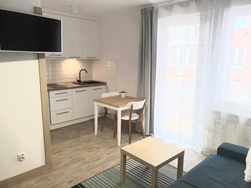 ein Wohnzimmer mit einer Küche und einem Esstisch in der Unterkunft Apartamenty Sztutowo in Sztutowo
