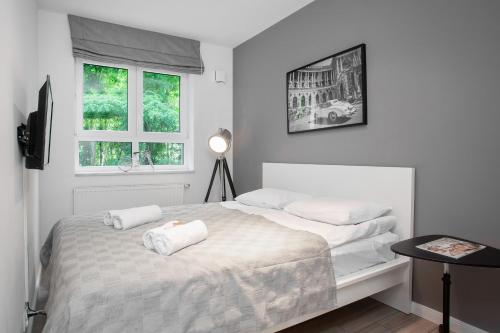 a bedroom with a bed with two towels on it at Apartments Parks of Warsaw by Renters in Warsaw