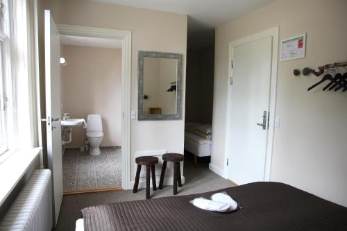 Un dormitorio con una cama y un baño con lavabo. en Stevns Klint Strandpension, en Rødvig