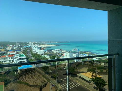 a view of a city and the ocean from a building at Lemain Hotel in Jeju