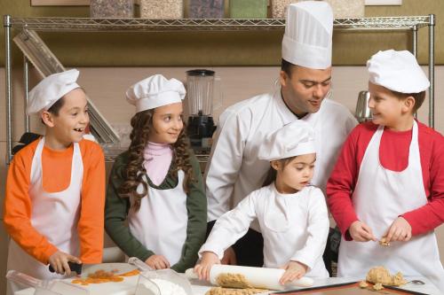 a group of people in a kitchen preparing food at Mövenpick Hotel Izmir in Izmir