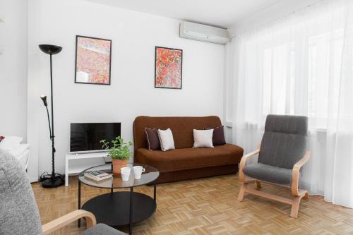 sala de estar con sofá y silla en Apartments Warsaw Kakowskiego by Renters en Varsovia
