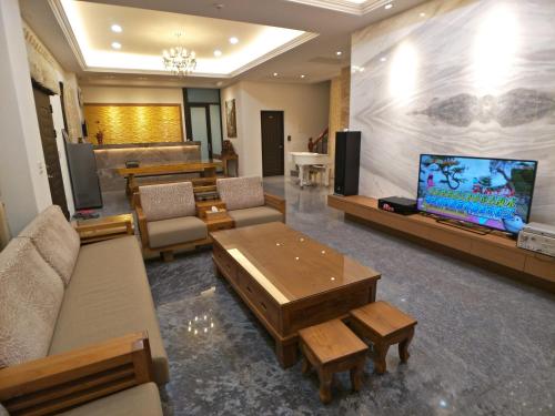 sala de estar con sofá, TV y mesas en Yellow Pui & Railway Inn, en Jiji