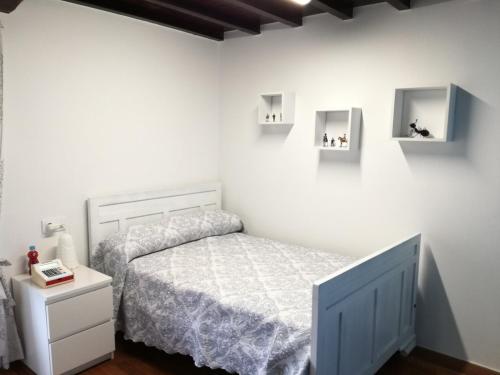 - une chambre avec un lit et des murs blancs dans l'établissement Casa rural Trabe, à Cedeira