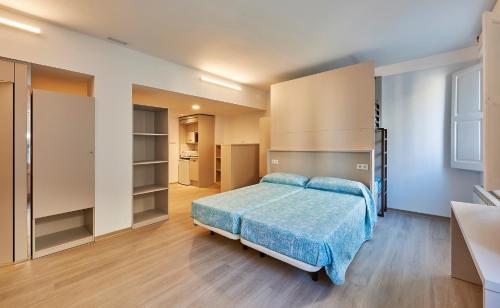 Alberg Abat Oliba في مونتسيرات: غرفة نوم كبيرة مع سرير ومطبخ