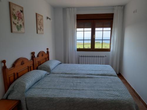 a bedroom with a large bed and a window at APARTAMENTOS EL SOLO in Santillana del Mar