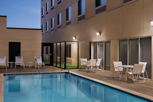 a pool with chairs and tables next to a building at Radisson Hotel Oklahoma City Airport in Oklahoma City