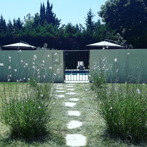 a garden with a fence and some grass and flowers at Le Mas Du Colombier in Cadenet