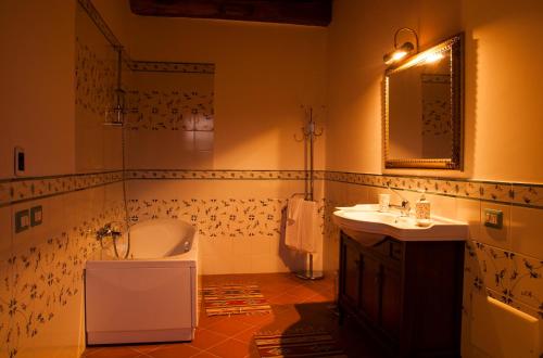 een badkamer met een bad, een wastafel en een spiegel bij Le Conche country house in Villamaina