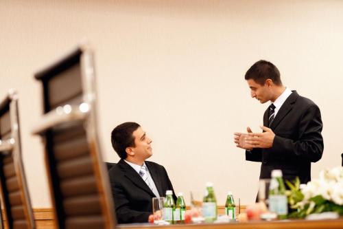 two men in suits sitting at a table at Mövenpick Hotel Izmir in Izmir