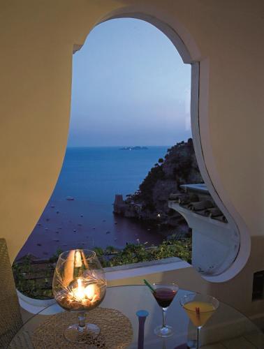 a room with a window with a view of the ocean at Hotel Punta Regina in Positano