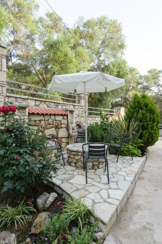 a patio with a chair and an umbrella at To Petrino (VIlla Markos) in Parga