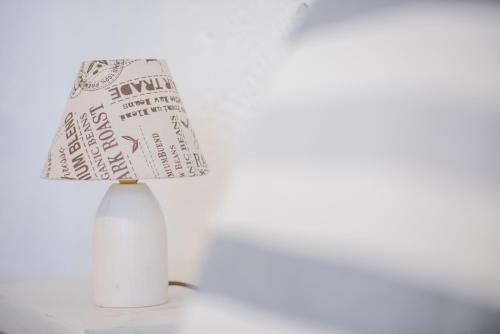 a white lamp with a paper lamp shade on a table at Apartment Nektarios in Grikos