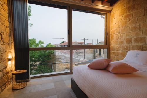 una camera con un letto e una grande finestra di Serenity Boutique House a Vouni