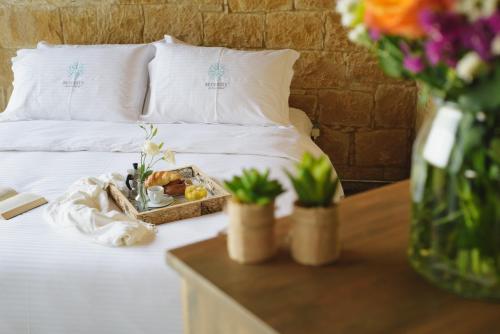 a bed with a tray of food and flowers on it at Serenity Boutique House in Vouni