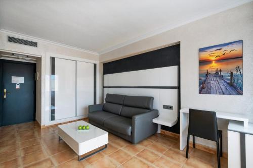 a living room with a couch and a table at Salles Hotels Marina Portals in Portals Nous