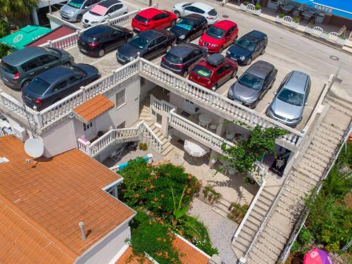a parking lot with cars parked in front of a building at Apartments Sentic in Neum