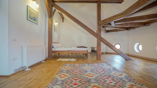 a room with a bed and a rug on a wooden floor at Baiulescu apartments in Braşov